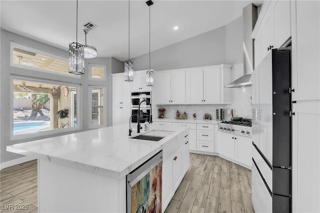 kitchen featuring light wood finished floors, visible vents, backsplash, beverage cooler, and appliances with stainless steel finishes