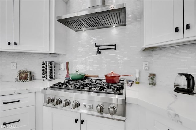 kitchen with decorative backsplash, white cabinetry, wall chimney exhaust hood, and stainless steel gas cooktop