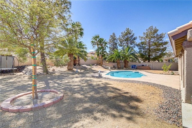 view of swimming pool featuring a trampoline, a patio area, a fenced in pool, and a fenced backyard