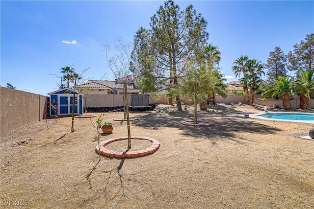 view of yard featuring an outdoor structure, a fenced backyard, and a shed