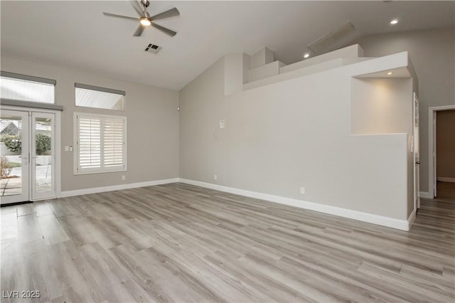 interior space with light wood-style flooring, baseboards, visible vents, and high vaulted ceiling