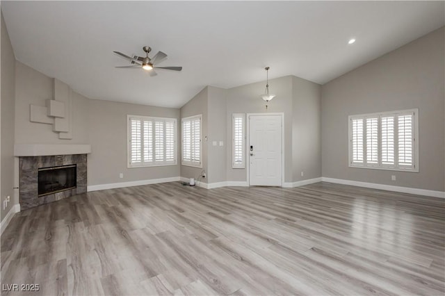 unfurnished living room with plenty of natural light, a ceiling fan, and vaulted ceiling