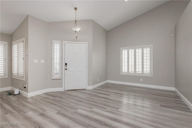 entrance foyer with lofted ceiling, wood finished floors, and baseboards