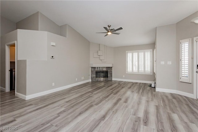 unfurnished living room with baseboards, plenty of natural light, light wood-style floors, and ceiling fan