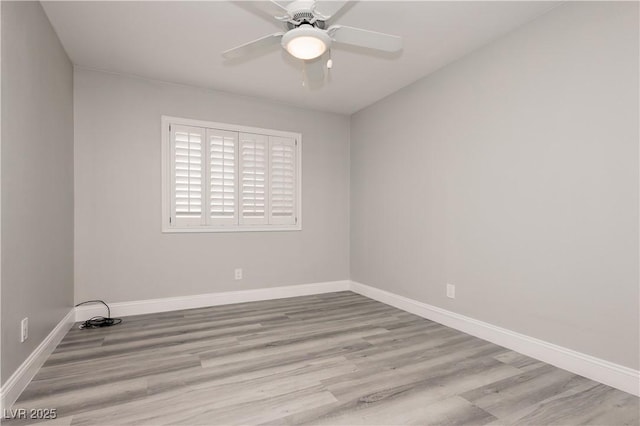 empty room with a ceiling fan, baseboards, and wood finished floors