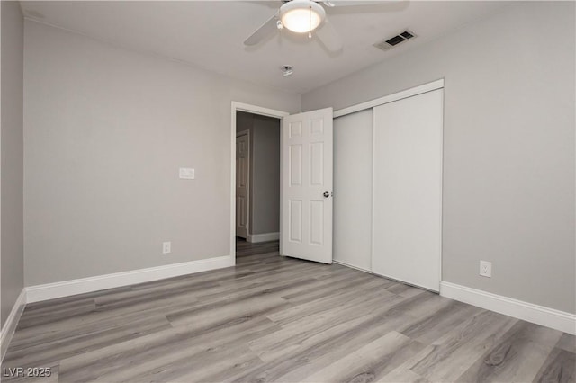 unfurnished bedroom with a ceiling fan, wood finished floors, baseboards, visible vents, and a closet