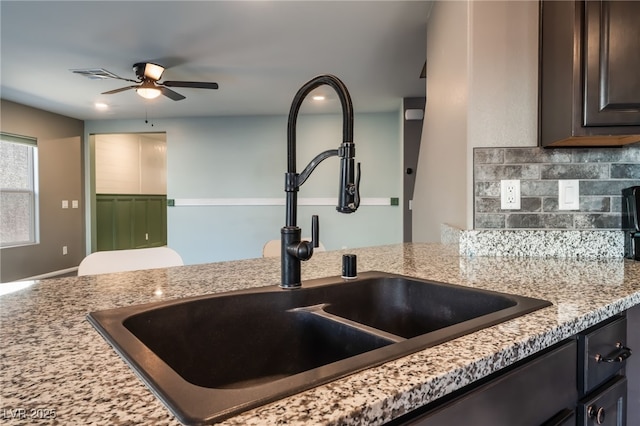 7219 Quiet Spring St, North Las Vegas, NV 89084 - kitchen featuring light stone counters, a sink, visible vents, dark brown cabinetry, and a ceiling fan