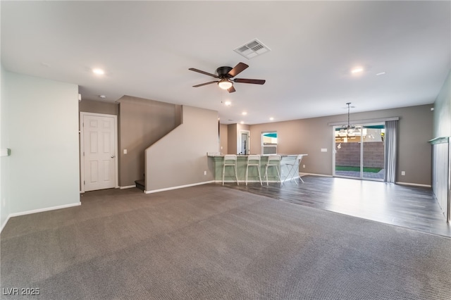 7219 Quiet Spring St, North Las Vegas, NV 89084 - unfurnished living room featuring carpet flooring, visible vents, baseboards, and ceiling fan with notable chandelier