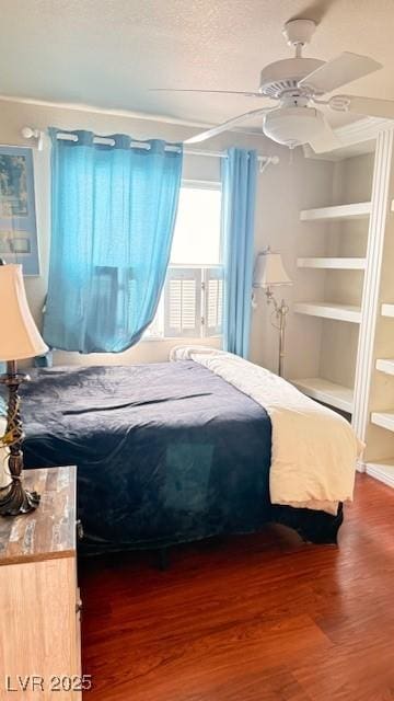 bedroom with a textured ceiling, ceiling fan, and wood finished floors