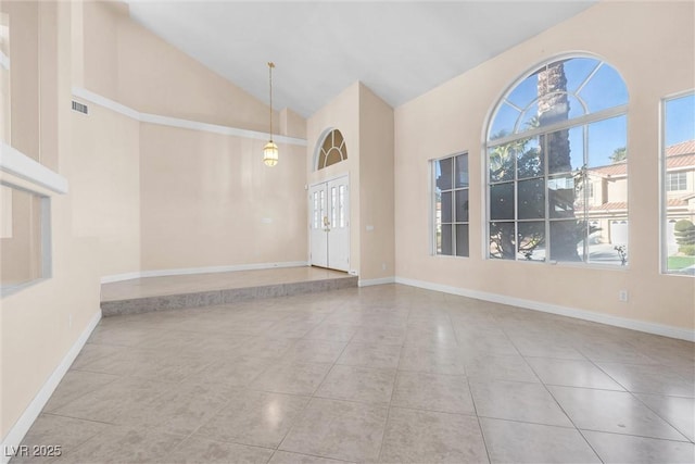 unfurnished room featuring tile patterned floors, visible vents, baseboards, and high vaulted ceiling