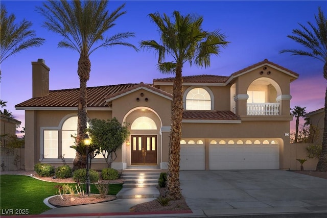 mediterranean / spanish-style house featuring an attached garage, stucco siding, concrete driveway, french doors, and a tile roof