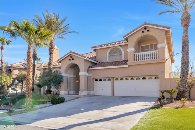 mediterranean / spanish-style home featuring a balcony, driveway, stucco siding, a garage, and a tiled roof