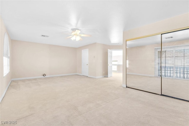 unfurnished bedroom with multiple windows, carpet floors, baseboards, and ceiling fan