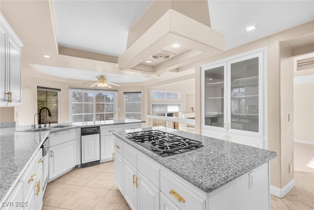 kitchen with a sink, gas cooktop, white cabinets, and a ceiling fan