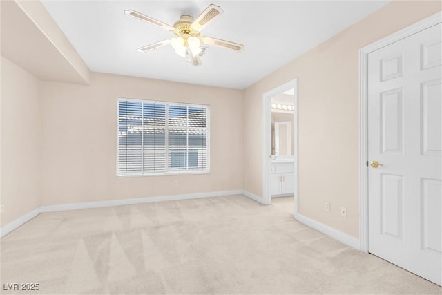 empty room featuring a ceiling fan, baseboards, and light carpet