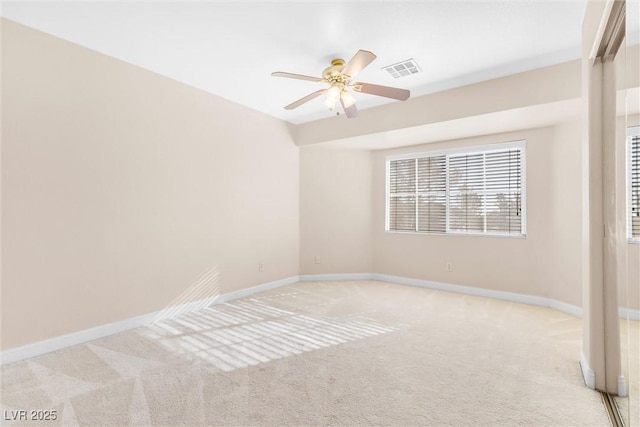 carpeted spare room featuring a ceiling fan, baseboards, and visible vents