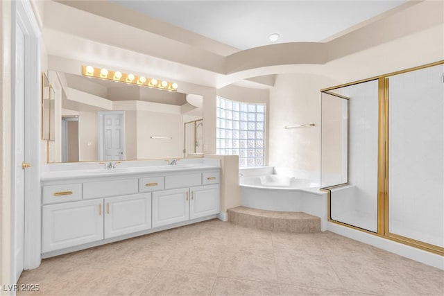 full bathroom featuring tile patterned floors, a garden tub, a stall shower, a sink, and double vanity