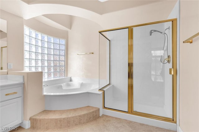 full bathroom with a shower stall, vanity, and a garden tub