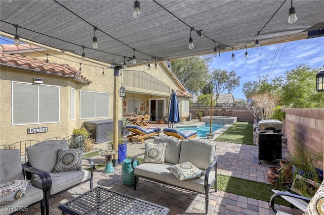 view of patio / terrace with outdoor lounge area, area for grilling, a fenced backyard, and a pool with connected hot tub