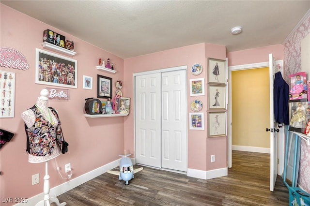 bedroom featuring a closet, baseboards, and wood finished floors