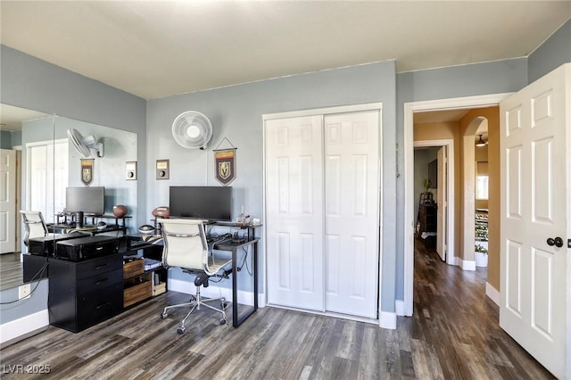 office space with baseboards, arched walkways, and dark wood-style floors