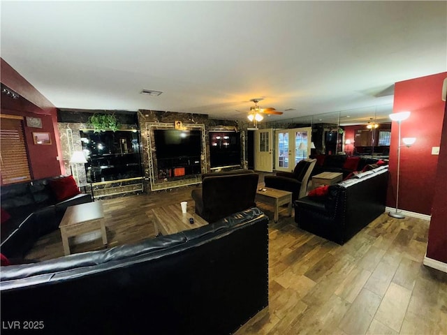 living area featuring wood finished floors, a ceiling fan, and visible vents