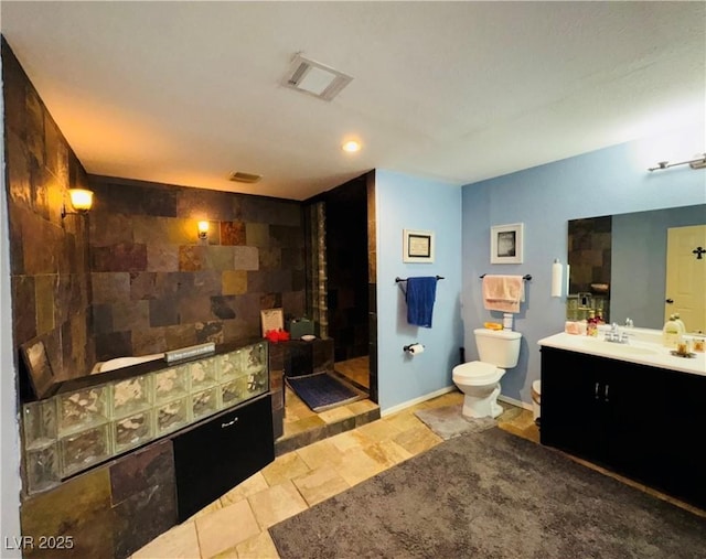 bathroom with visible vents, toilet, a walk in shower, baseboards, and vanity