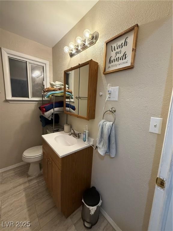 1016 Park Ave, Ely, NV 89301 - bathroom featuring toilet, vanity, and baseboards