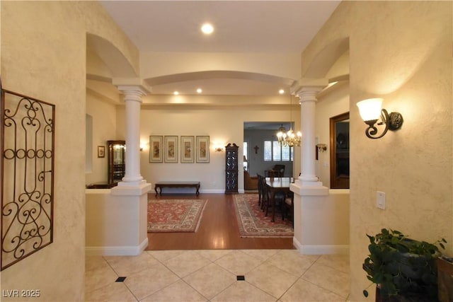 tiled foyer entrance featuring arched walkways, recessed lighting, baseboards, and ornate columns