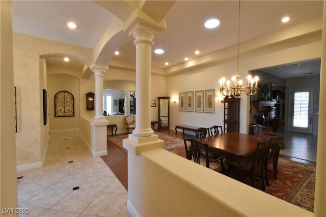 dining space with arched walkways, light tile patterned floors, recessed lighting, and decorative columns