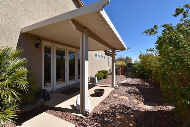 exterior space with french doors, a patio area, and stucco siding