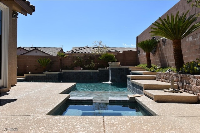 view of swimming pool featuring a pool with connected hot tub and a fenced backyard