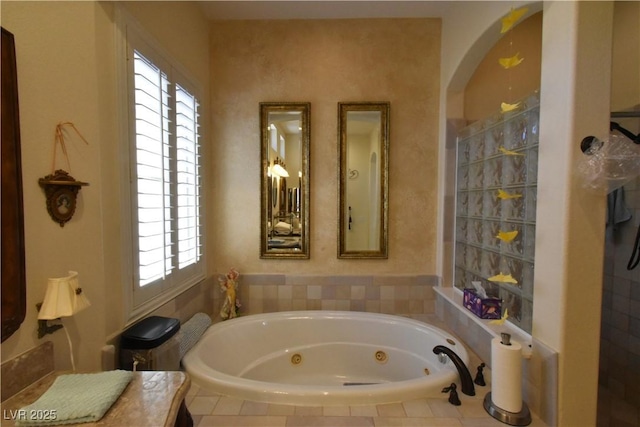 bathroom with a tub with jets and a wealth of natural light