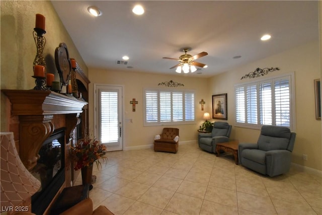 living room with light tile patterned floors, a ceiling fan, baseboards, recessed lighting, and a glass covered fireplace