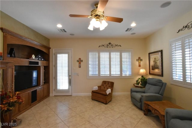 living area with light tile patterned floors, visible vents, and a wealth of natural light