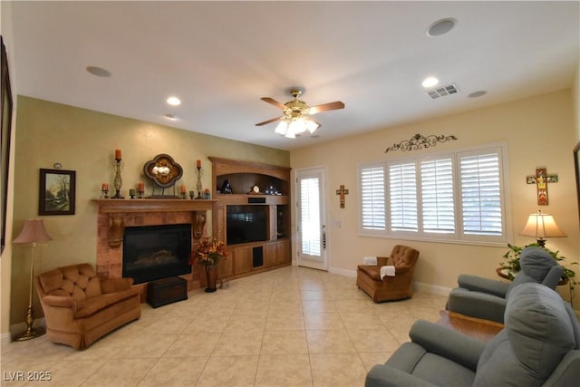 living area featuring a ceiling fan, baseboards, light tile patterned flooring, recessed lighting, and a glass covered fireplace