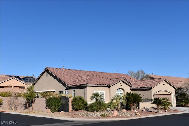 view of front of home featuring stucco siding, a tiled roof, and an attached garage