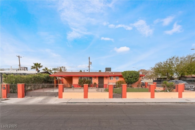 view of front of house with a fenced front yard, driveway, and a gate