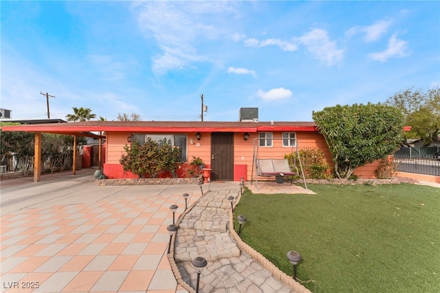 ranch-style home with an attached carport, driveway, a front lawn, and fence