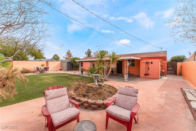 view of patio / terrace featuring an outdoor structure, a fenced backyard, and a shed