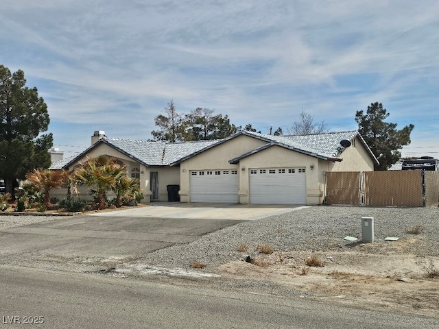 ranch-style home with stucco siding, driveway, an attached garage, a tile roof, and fence