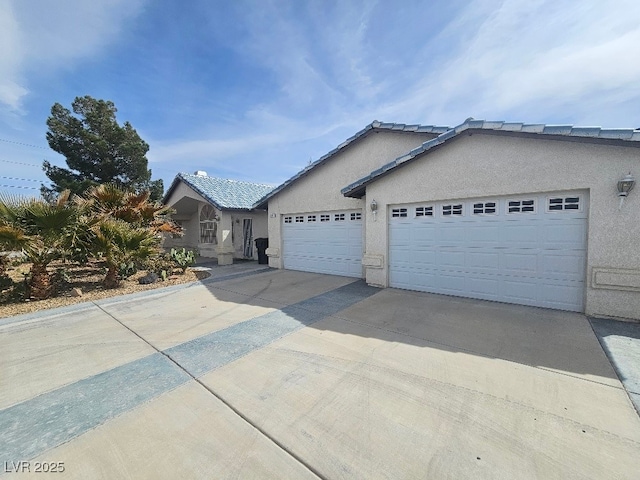 single story home with stucco siding, a garage, and driveway