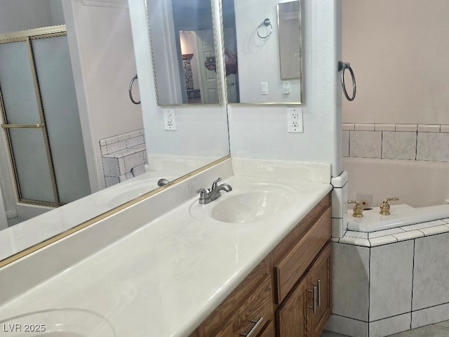 bathroom featuring a shower with door, double vanity, a bath, and a sink