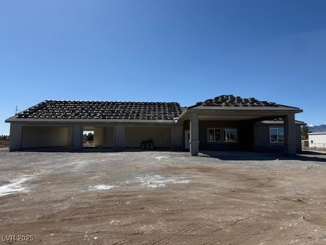 back of house featuring driveway and an attached garage