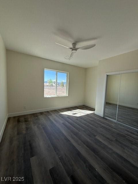 unfurnished bedroom with wood finished floors, baseboards, a closet, and ceiling fan