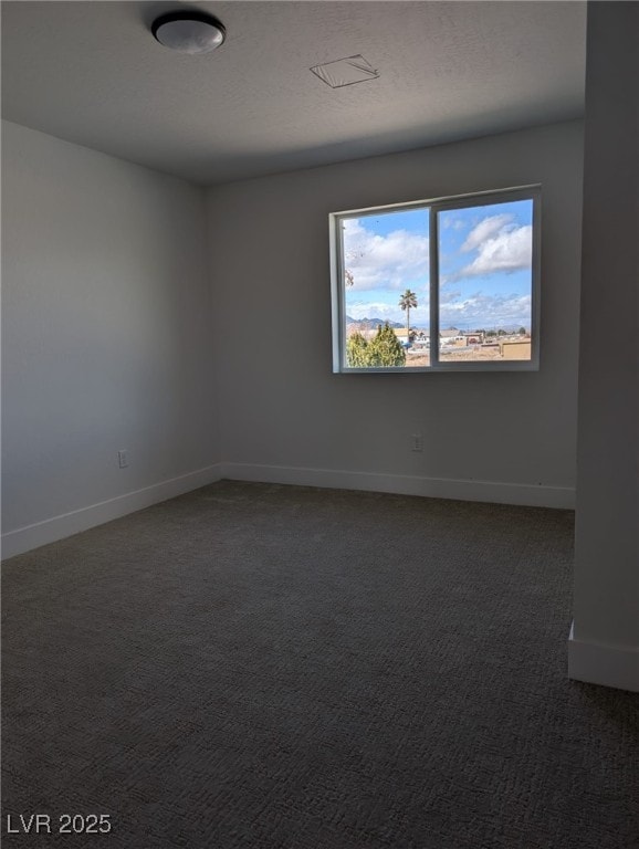 unfurnished room with baseboards, carpet floors, and a textured ceiling