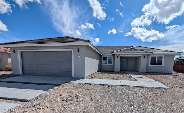 ranch-style house featuring driveway, a garage, a tiled roof, and stucco siding