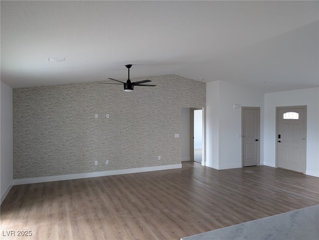 unfurnished living room with baseboards, lofted ceiling, wood finished floors, and ceiling fan
