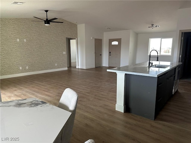 kitchen featuring dark wood-style floors, vaulted ceiling, ceiling fan, and a sink