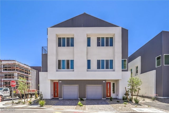 8629 Ensworth St Unit 114, Las Vegas, NV 89123 - view of front facade featuring a garage, driveway, and stucco siding